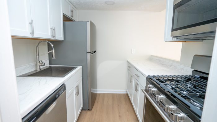 a kitchen with stainless steel appliances and white cabinets at The Lakeshore Cove