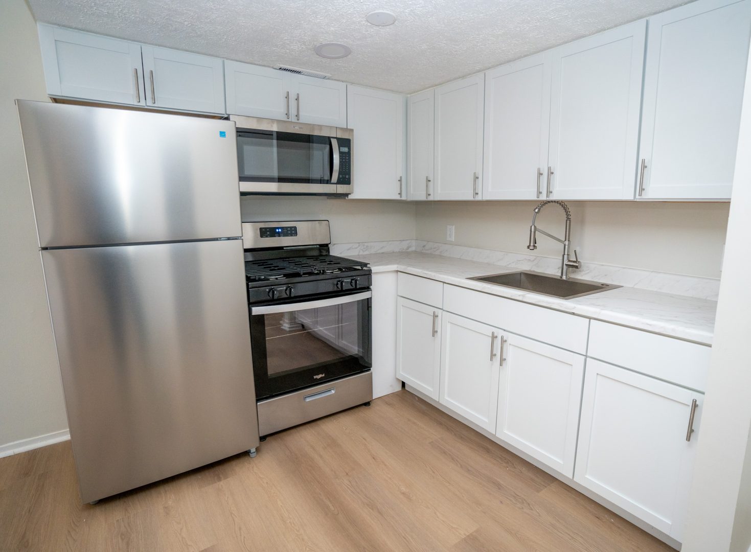 a kitchen with stainless steel appliances and white cabinets at The Lakeshore Cove