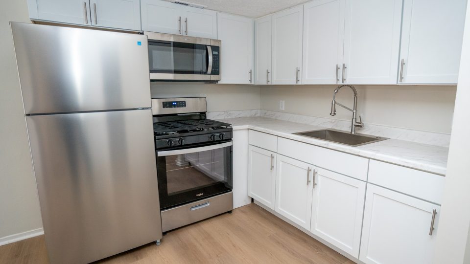 a kitchen with stainless steel appliances and white cabinets at The Lakeshore Cove