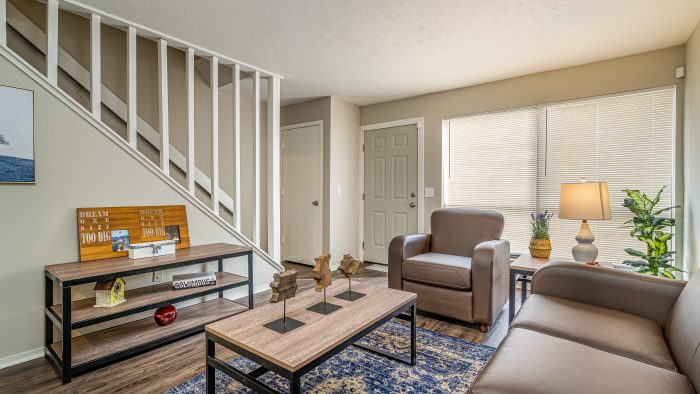 a living room with a couch, coffee table and stairs at The Lakeshore Cove